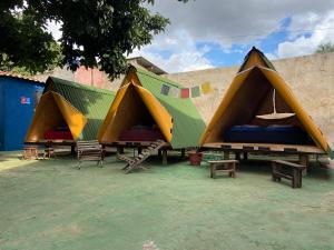 un groupe de tentes avec bancs et tables dans l'établissement Ashram no Paraíso., à Alto Paraíso de Goiás