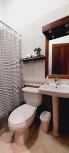 a bathroom with a toilet and a sink at Hotel Plaza Kavia in Santo Domingo