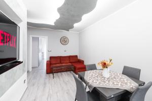 un soggiorno con divano rosso e tavolo di [5 min dal Centro] Cozy House a Torino