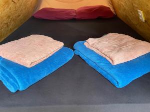 two towels are sitting on the floor of a bed at Ashram no Paraíso. in Alto Paraíso de Goiás