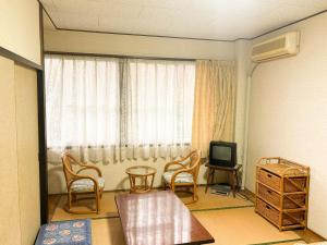 a living room with a table and chairs and a television at Eco Hotel Yunokosou - Vacation STAY 99127v in Minamata