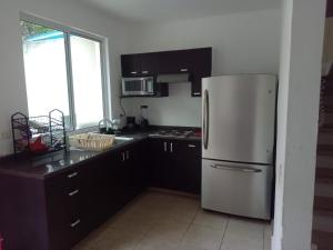 eine Küche mit Edelstahlkühlschrank und Fenster in der Unterkunft Parque 44 in Playa del Carmen