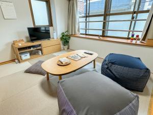 sala de estar con mesa y silla en Fukuoka - Apartment - Vacation STAY 00143v en Fukuoka