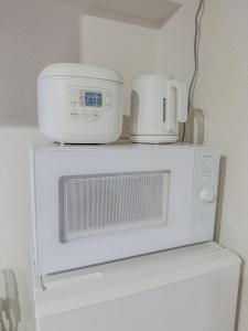 a white microwave with two cups on top of it at Fukuoka - Apartment - Vacation STAY 00143v in Fukuoka