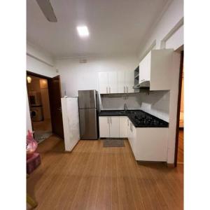 a kitchen with white cabinets and stainless steel appliances at Ocean Apartments Hulhumale (Lot 10819) in Male City