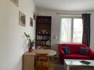 salon z czerwoną kanapą i stołem w obiekcie Apartament przy Parku Czartoryskich w mieście Puławy