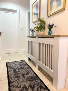 a hallway with a console table with flowers and plants at Pine View In The Heart Of The West in Lisacul