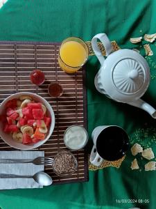 a table with a tray with a bowl of fruit and a tea kettle at Antigua Sweet Apartment in Antigua Guatemala