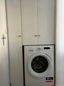 eine Waschmaschine in einem Zimmer mit einem weißen Schrank in der Unterkunft Villa des Ixoras in Baie-Mahault