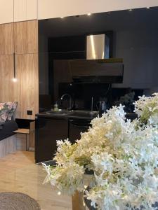 a kitchen with a stove and some white flowers at Lux Dabic 1 in Novi Sad