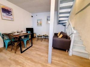 a dining room and living room with a table and a staircase at Maison La Petite Bleue - Balcon - Wifi Fibre - Menage inclus in Tarbes