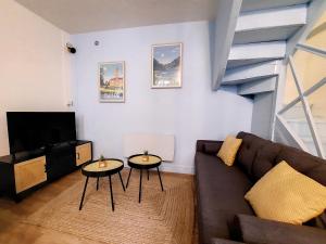 a living room with two tables and a couch at Maison La Petite Bleue - Balcon - Wifi Fibre - Menage inclus in Tarbes
