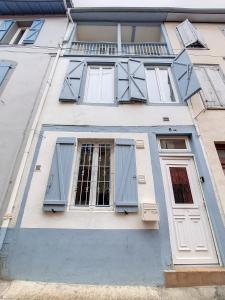 um edifício branco com persianas azuis em Maison La Petite Bleue - Balcon - Wifi Fibre - Menage inclus em Tarbes