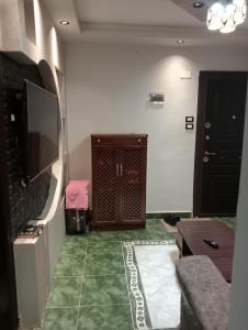 a living room with a television and a green floor at شقة فندقية في بورسعيد in Port Said