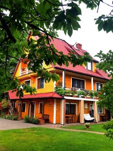 スプラシルにあるpokoje wypoczynkowe "Róża"の赤い屋根の大きなオレンジ色の家