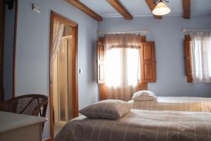 1 dormitorio con cama, ventana y puerta en Apartamento Turístico El Sotanillo de Valverde de la Vera, en Valverde de la Vera