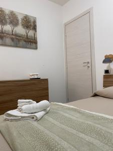 Al Larghetto في لاميزيا تيرمي: غرفة نوم عليها سرير وفوط