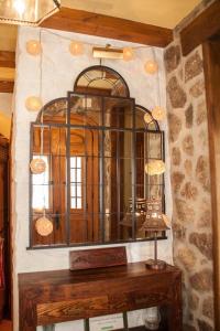 un espejo en una pared de piedra con una mesa de madera en Apartamento Turístico El Sotanillo de Valverde de la Vera, en Valverde de la Vera