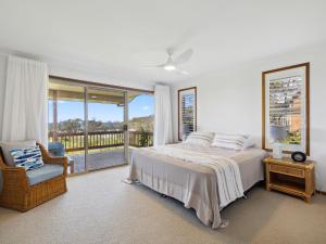 - une chambre avec un lit et un balcon dans l'établissement Gerry's Mullawarra Beach House, à Arrawarra