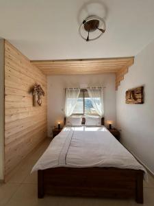 um quarto com uma cama grande e uma janela em ROSEHILLS em Kefar Weradim