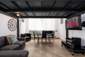 un soggiorno con TV e tavolo con sedie di Porta Susa - Liberty Loft a Torino