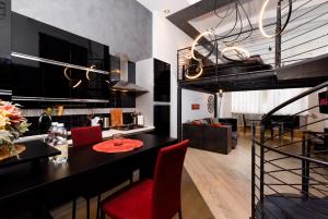 una cucina e una sala da pranzo con tavolo nero e sedie rosse di Porta Susa - Liberty Loft a Torino