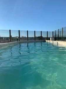卡洛斯帕斯的住宿－Hermoso y calido depto centrico，碧绿的蓝色海水游泳池