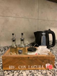 uma caixa de madeira com 2 garrafas e comodidades para preparar café em Hermoso y calido depto centrico em Villa Carlos Paz
