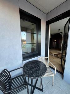 a table and chairs on a balcony with a room at WIDOKI3 Apartment Montownia Foodhall in Gdańsk