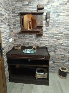 y baño con lavabo de madera y espejo. en Casa Rural La Antigua Fonda (@casarural_laantiguafonda), en Requena