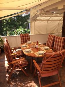 a wooden table and chairs on a patio at Vila Ceder in Krk
