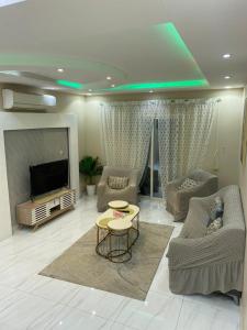 Happiness Place في King Abdullah Economic City: غرفة معيشة مع تلفزيون وأريكة وطاولة