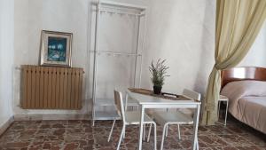 1 dormitorio con mesa, sillas y 1 cama en Palazzo montagna, en Grotte