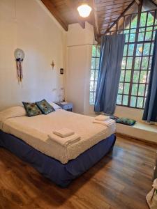 una camera con un grande letto in una stanza con finestre di DEPARTAMENTO EN DORREGO a Guaymallén