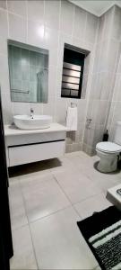 a white bathroom with a sink and a toilet at Ballito Hills Lifestyle Estate in Ballito