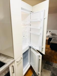 an empty refrigerator with its door open in a kitchen at SEEMOMENTE Spieleland, Messe, Friedrichshafen 3 Zi mit Balkon, Parkplatz in Meckenbeuren