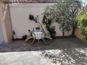 a table and chairs on a patio with a tree at Στουντιο Βολος Ν Ιωνια in Volos