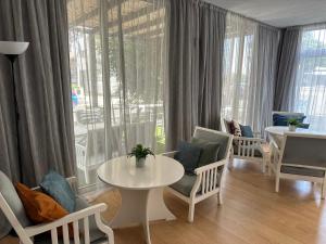 ein Wohnzimmer mit einem Tisch und Stühlen sowie einem großen Fenster in der Unterkunft Pasithea Holiday Apartments in Larnaka