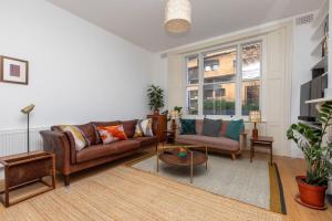 a living room with a couch and a table at Spacious 2BD Flat By Regents Park & Camden Town! in London