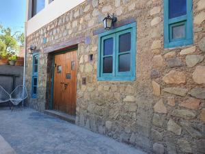 un edificio in pietra con porta e finestre in legno di La Llama Negra a Tilcara