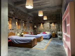 La Llama Negra في تيلكارا: غرفة نوم بسريرين وجدار حجري