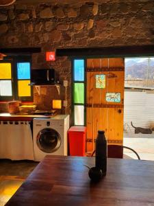 a kitchen with a table and a washing machine at La Llama Negra in Tilcara