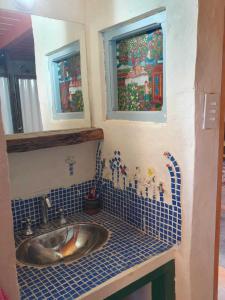 a bathroom with a sink and two windows at La Llama Negra in Tilcara