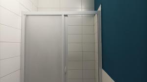 La salle de bains est pourvue d'une porte de douche et d'un mur bleu. dans l'établissement Palazzo montagna, à Grotte