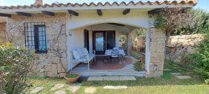 a stone house with a patio with a table and chairs at Lupo 1 in Cannigione
