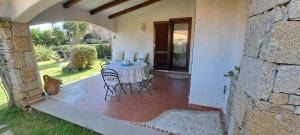 un patio con tavolo e sedie in una casa di Lupo 1 a Cannigione