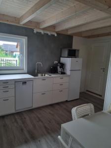 a kitchen with white cabinets and a white refrigerator at Domki letniskowe bez zwierząt in Międzyzdroje