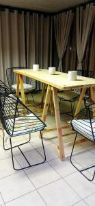 een houten tafel met twee kopjes en twee stoelen bij Bakaya Hotel Tlokweng in Gaborone