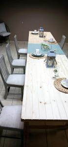 een lange houten tafel met stoelen en borden erop bij Bakaya Hotel Tlokweng in Gaborone