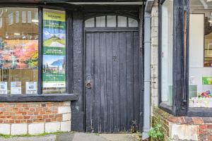 czarne drzwi na boku budynku w obiekcie Oxted High St w mieście Titsey